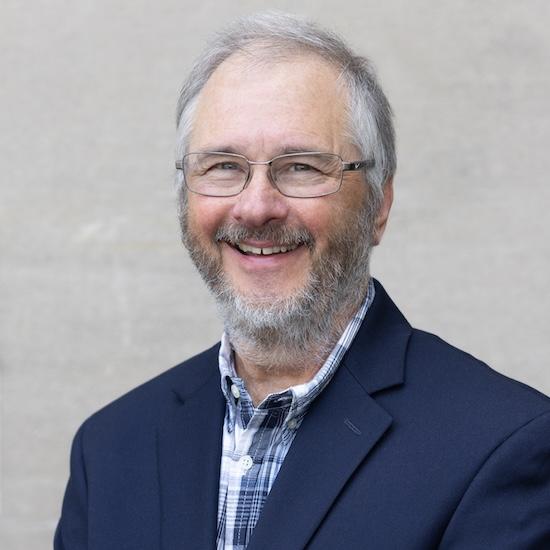 A smiling Thom Opar in a blue suit.